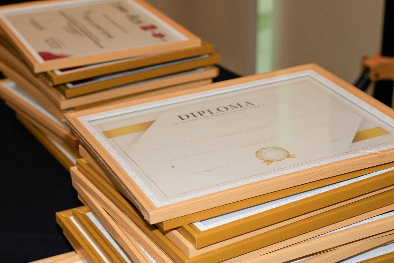 Framed diplomas stacked and ready for a certification ceremony